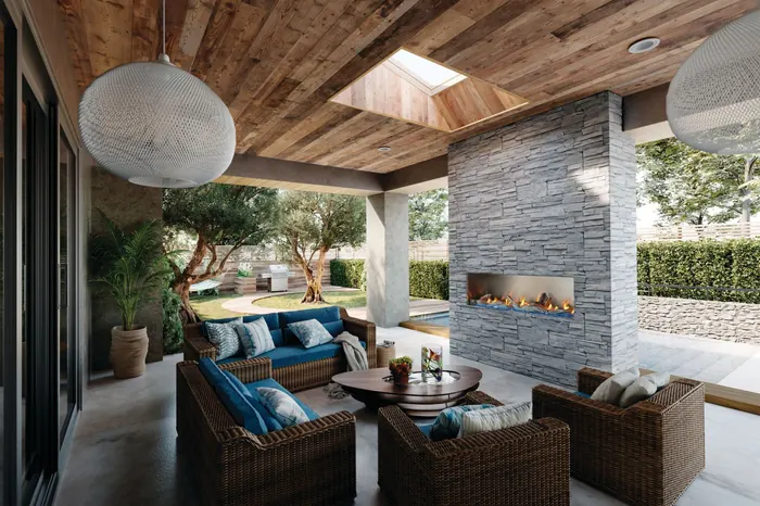 Napoleon Galaxy 74 outdoor gas fireplace in a grey stacked-stone wall on a covered backyard patio with wicker seating